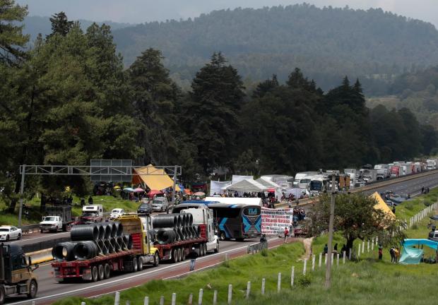 Turistas y habitantes optaron por caminar debido al bloqueo que pobladores de Santa Rita Tlahuapan mantuvieron en la autopista México-Puebla.