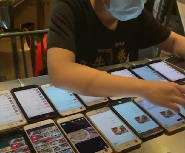 La joven de China atiende pedidos y publicidad con todos esos celulares