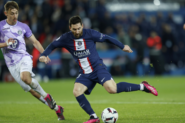 Lionel Messi del Paris Saint-Germain patea el balón mientras lo defiende Anthony Rouault del Toulouse en el encuentro de la liga francesa