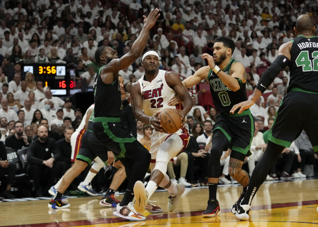 El alero de los Boston Celtics Jayson Tatum (0) y el guardia Jaylen Brown (7) defienden al alero del Miami Heat Jimmy Butler (22) durante el Juego 3 de las finales de la Conferencia Este de la NBA