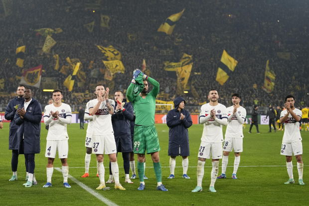 Futbolistas del PSG celebran su clasificación a los octavos de final de Champions League después de empatar 1-1 en Alemania con el Borussia Dortmund.