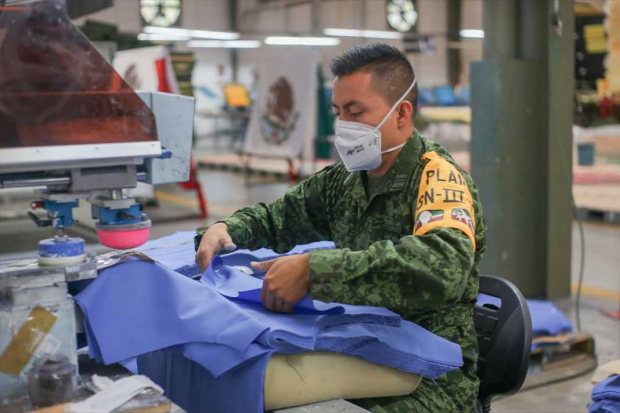 Confeccionan militares uniformes y materiales  para personal médico, ayer.