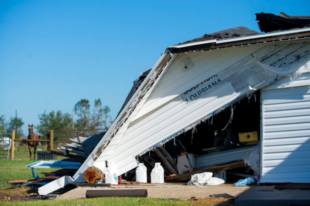 Un garaje parcialmente destruido por el huracán Laura tiene escrita la palabra "Luisiana".
