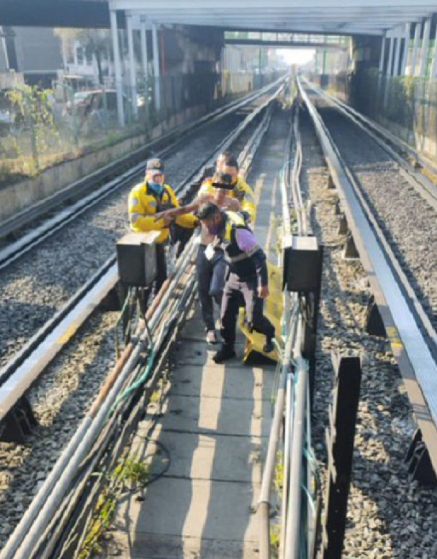 Personal de seguridad aparta al hombre de las vías del Metro, este martes