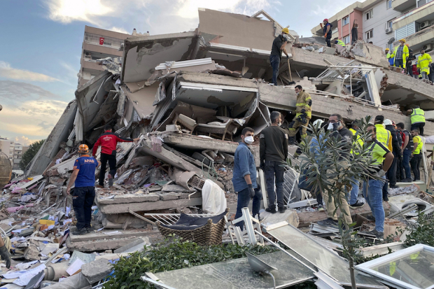 Equipos de rescate buscan entre los escombros de un edificio colapsado en Izmir, Turquía.