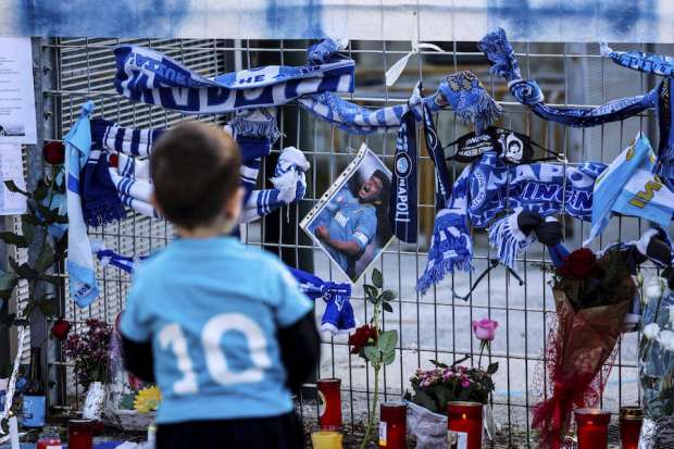 Un aficionado contempla las ofrendas afuera del Estadio del Napoli.