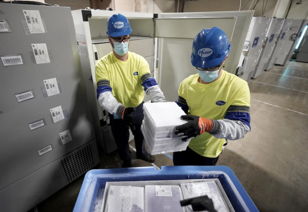 Personal de Pfizer/BioNTech guardan cajas con la vacuna desarrollada por ese laboratorio para su producción, en imagen de archivo.