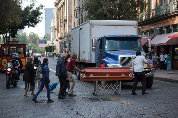 En Allende y 5 de Mayo, dos personas transportan un ataúd, ayer.