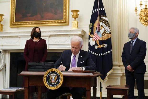 El presidente de EU, Joe Biden, firma más de 10 órdenes para delinear el cambio en el Gobierno, ayer.