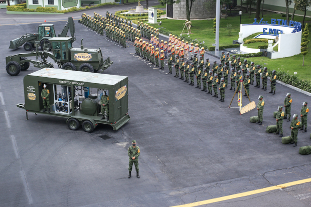 Personal del Ejército frente a excavadoras y una unidad móvil para purificar agua, en el Campo Militar 1.