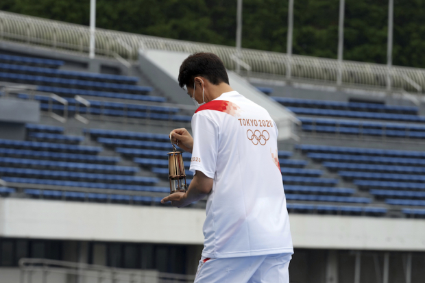 Un atleta llega al Parque Olímpico de Komazawa con la linterna que contiene la flama olímpica, ayer.