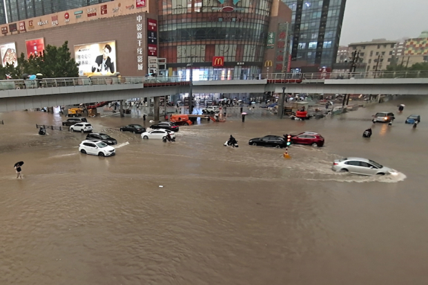 Vehículos varados en medio del agua, ayer, en Zhengzhou.