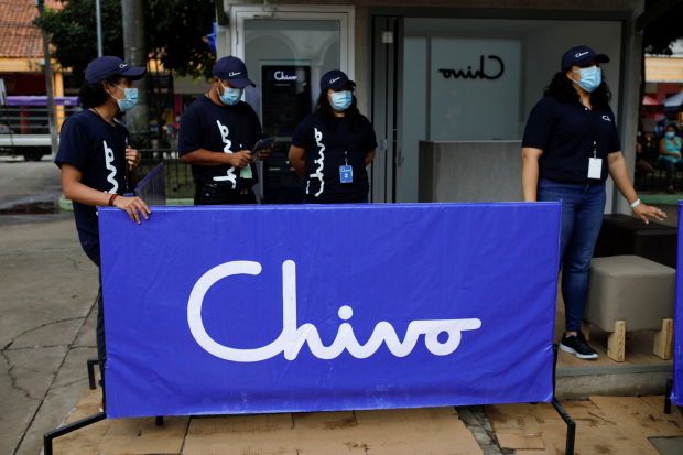 Trabajadores esperan a personas interesadas en el uso de Bitcoin, afuera de un cajero automático de la billetera Chivo.