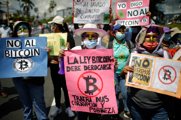 Personas protestan contra el uso del Bitcoin como moneda de curso legal.
