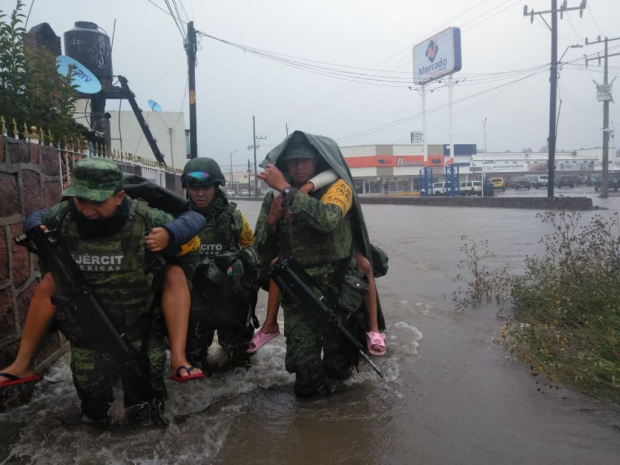 Personal militar auxilia, ayer, a afectados por el desbordamiento del canal El Brillante, en Durango.