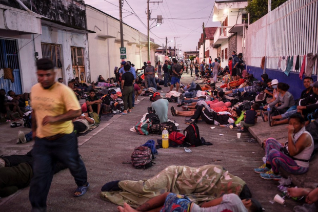 Migrantes descansan, ayer, en los alrededores de la iglesia de Huixtla.