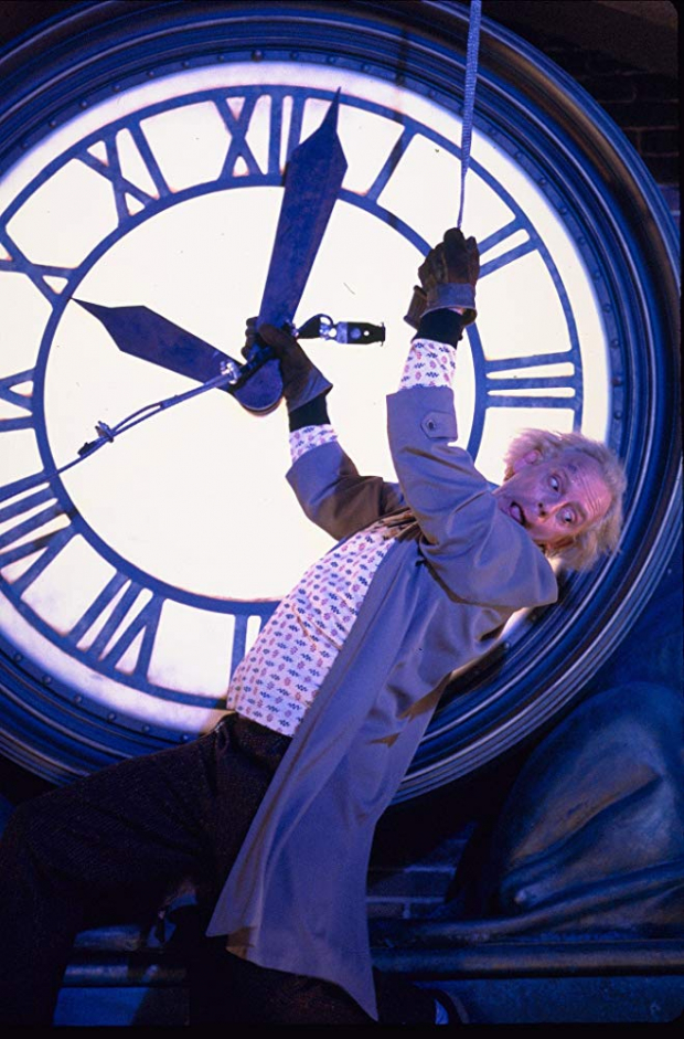 El Dr. Emmett Brown de Volver al Futuro actualizando un reloj.