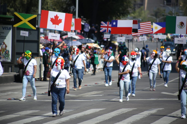Personas con banderas de diferentes nacionalidades desfilan en la Ciudad de México.