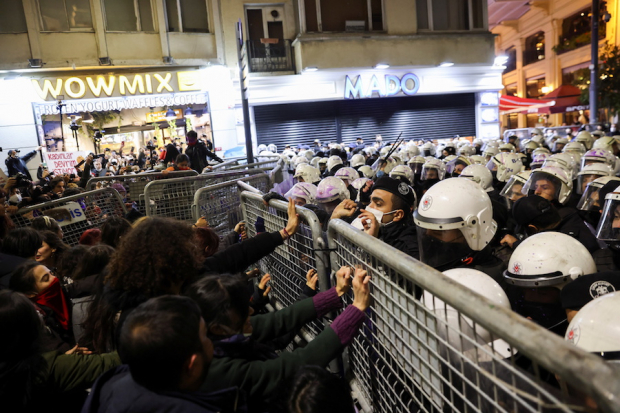 Mujeres en Estambul intentan evitar barricada de la Policía, ayer.