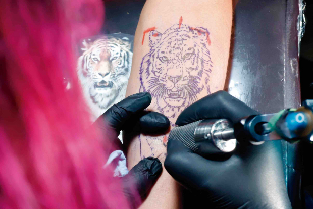 Una persona se hace un tatuaje, en la ciudad de Puebla.