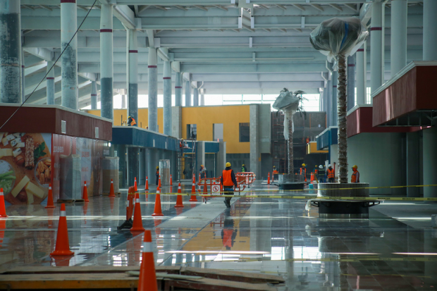 Trabajadores afinan los últimos detalles a pisos y fachadas del interior del aeropuerto.