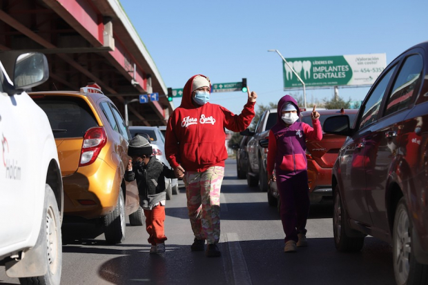 Niños migrantes piden dinero a automovilistas, en Saltillo, Coahuila.