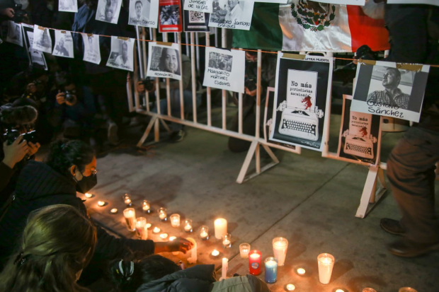 Periodistas ponen veladoras ante las imágenes de colegas asesinados en años recientes.