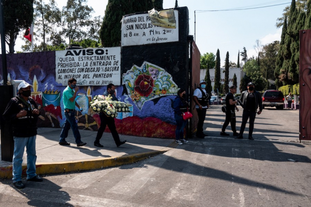 Personas llevan flores al panteón de San Nicolás Tolentino, en Iztapalapa, de donde fue exhumado el bebé Tadeo.
