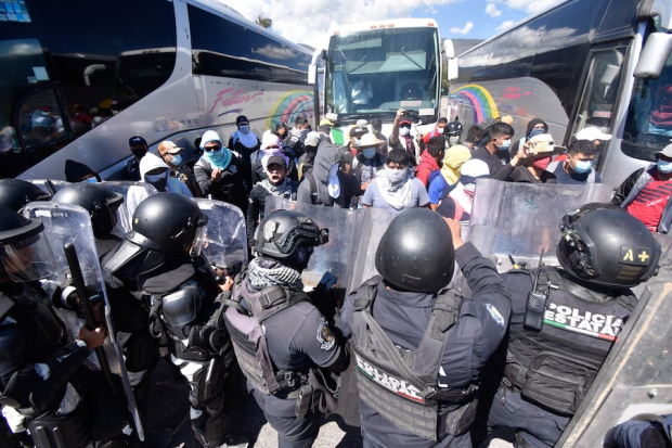 Elementos de la Policía Estatal, equipados con escudos y cascos, repliegan a los estudiantes de Ayotzinapa.