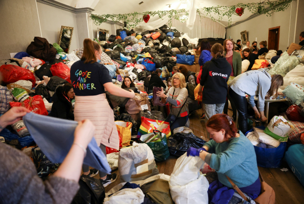 Ciudadanos buscan ayuda entre las donaciones recibidas para refugiados.
