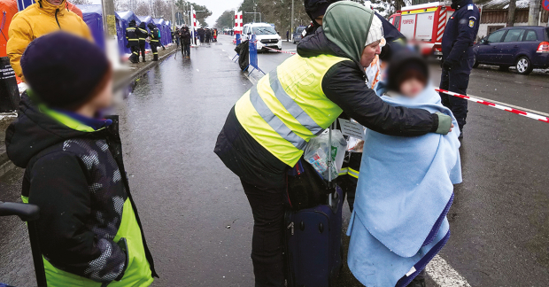 Una mujer le pone una cobija a un niño refugiado que llegó de Ucrania a la ciudad fronteriza de Siret, en Rumania, ayer.