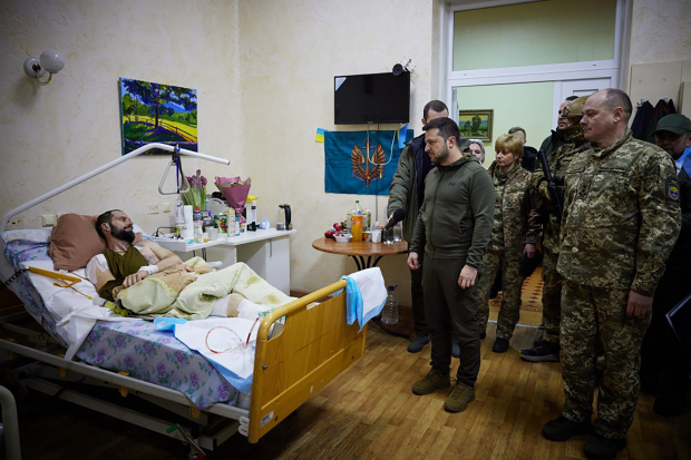 El Presidente Volodímir Zelenski platica con un soldado herido, durante su visita a un hospital en Kiev, Ucrania, ayer.