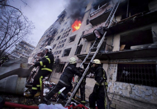 Bomberos responden al impacto de un proyectil contra un edificio en Kiev.