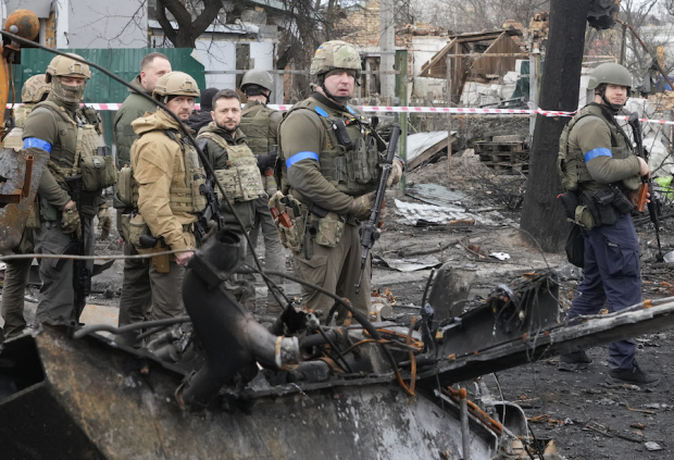 El presidente Volodimir Zelenski (al centro sin casco) observa, ayer, la devastación en Bucha.
