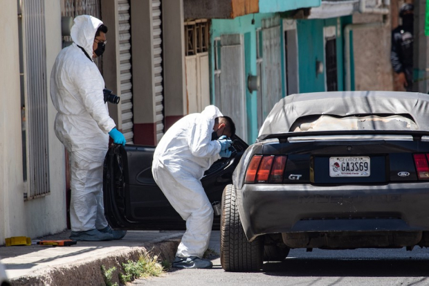 Peritos de la Fiscalía estatal laboran en el lugar donde un hombre fue asesinado en su auto, en Guadalupe, el pasado 10 de abril.