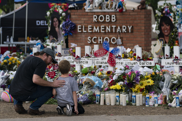 Un hombre y un niño visitaron el monumento instalado en la primaria Robb, en Uvalde, Texas, para honrar a las 21 víctimas del tiroteo del martes, ayer.