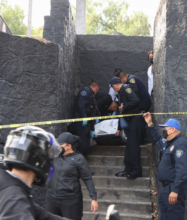 Policías retiran el cuerpo de un joven que se colgó de un puente peatonal en Río Churubusco y Albert, en la colonia el Retoño, en la Ciudad de México, ayer.