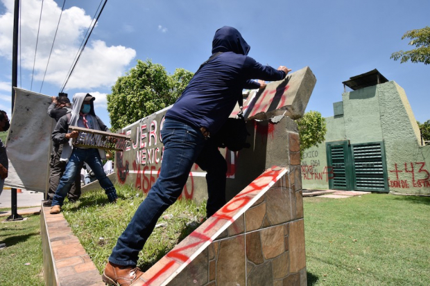 Estudiantes realizan pintas y destrozos al exterior del 27 Batallón de Infantería en Iguala, ayer.