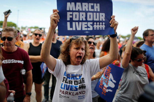 Una mujer grita mientras sostiene una pancarta durante un mitin de "Marcha por nuestras vidas.