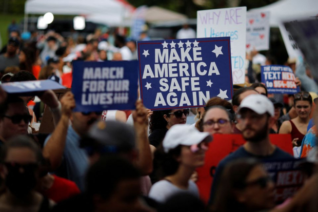 Una mujer sostiene una pancarta que dice "Hacer que Estados Unidos vuelva a ser seguro" durante una marcha por el control de armas "Marcha por nuestras vidas" en Parkland, Florida.