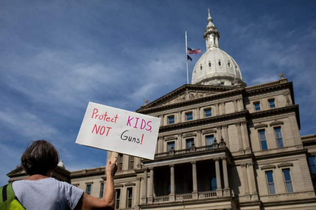 Un participante sostiene un cartel afuera del Capitolio del Estado de Michigan durante una manifestación de la Marcha por Nuestras Vidas para el control de armas en Lansing, Michigan.
