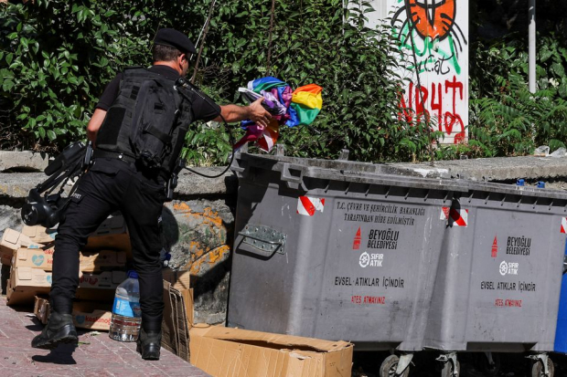 Policía lanza una bandera del arcoíris en un basurero mientras los activistas intentan marchar en el Pride.