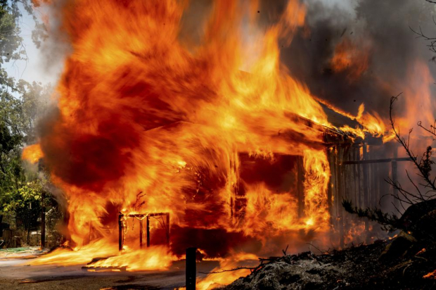 Las llamas del "Oak" consumen una casa en Triangle Rd. en el condado de Mariposa, California.