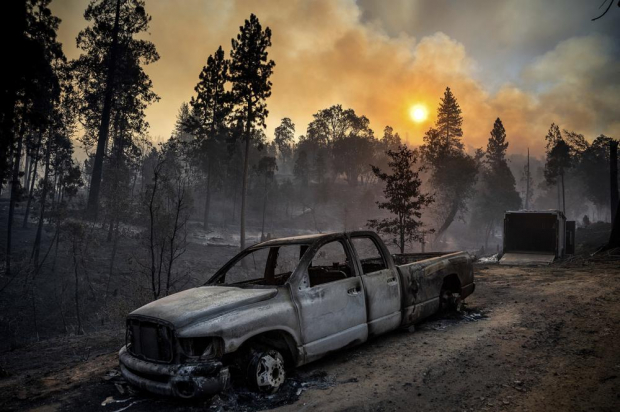 "Oak" arde detrás de una camioneta quemada en la comunidad de Jerseydale del condado de Mariposa, California.