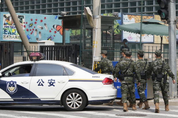 Militares pasan frente a la embajada de EU en Beijing, en medio de la disputa.