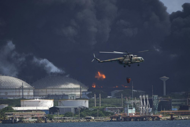 Un helicóptero que lleva agua sobrevuela la base de superpetroleros de Matanzas.