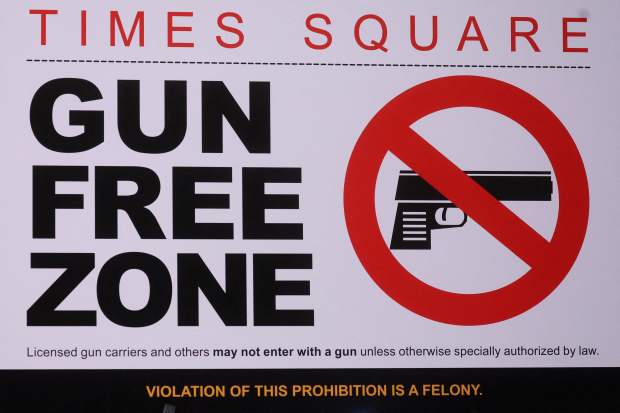 Un letrero similar al que se publicará en la "zona libre de armas" de Times Square se muestra antes de una conferencia de prensa sobre las nuevas leyes de armas en Nueva York.