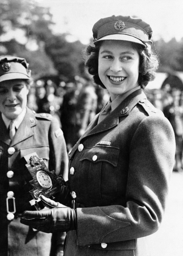La princesa Isabel de Gran Bretaña, comandante menor en el servicio auxiliar territorial, recibe un reloj como regalo de los viejos asociados en el campamento donde recibió su entrenamiento, durante una ceremonia en el Centro de Entrenamiento No. 1 en Camberley, Inglaterra, el 3 de agosto de 1945