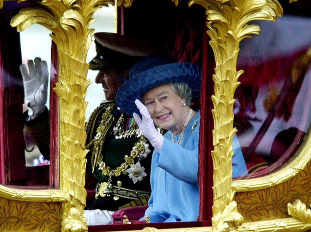 La reina Isabel II de Gran Bretaña acompañada por su esposo el duque de Edimburgo saluda al público desde la carroza State Gold el 4 de junio de 2002, en un recorrido desde el Palacio de Buckingham a la Catedral de San Pablo en Londres rumbo a una misa de acción de Gracias por su Jubileo de Oro.