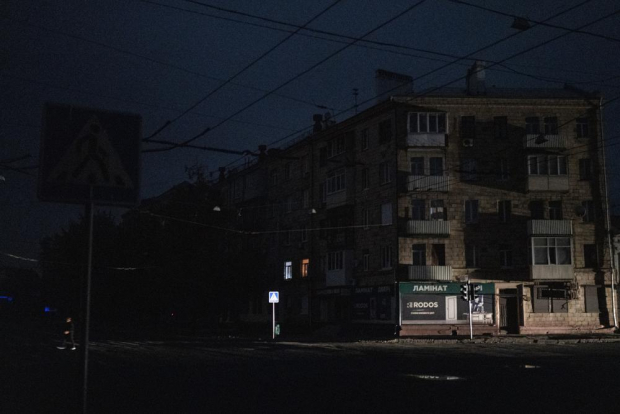 Un hombre cruza una calle completamente oscura en Járkov, Ucrania, el domingo 11 de septiembre de 2022.